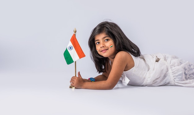 Niña linda con la bandera tricolor nacional de la India, aislado sobre fondo blanco. Adecuado para el concepto del Día de la Independencia o el Día de la República