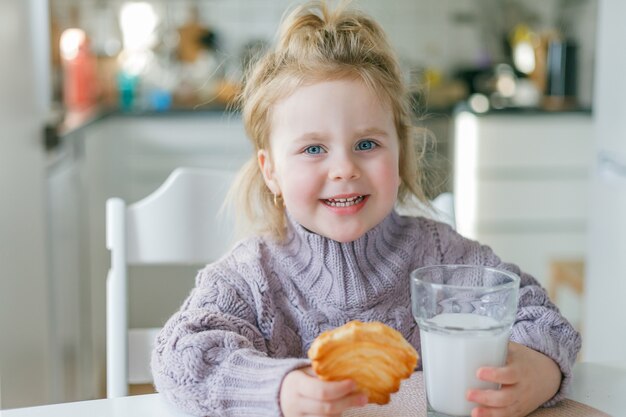 Niña linda bebe leche y come galletas. Helthy.