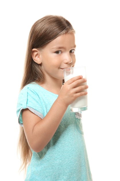 Niña linda bebiendo leche en blanco