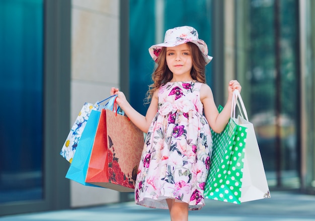 Niña linda con bolsas de compras