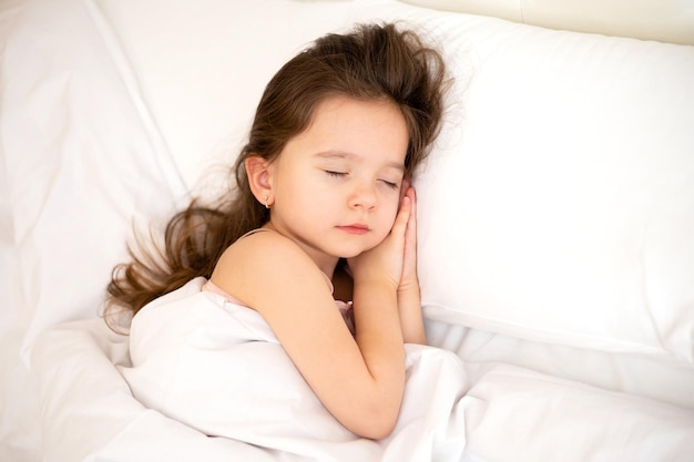 Una niña linda y bonita duerme en una almohada blanca Estilo de vida en el dormitorio de la mañana