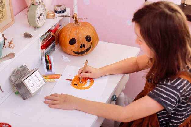 Niña linda con calabaza tallada