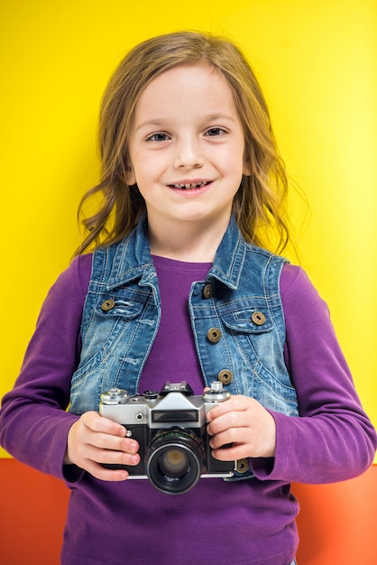 Foto niña linda con cámara de fotos retro