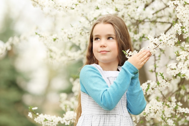 Niña linda caminando en el parque de la primavera