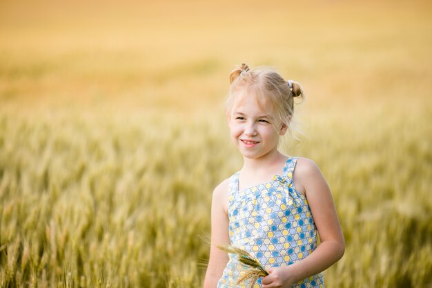 Niña linda en el campo de centeno.