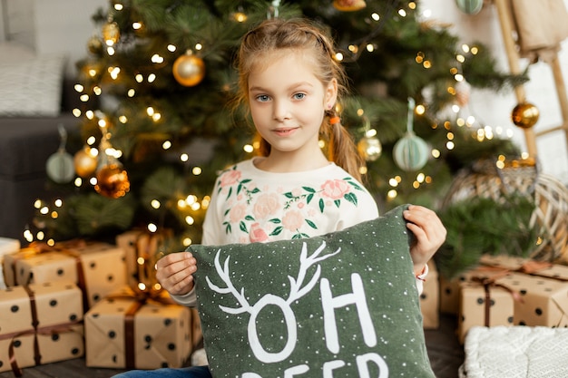 Niña linda cerca del árbol de navidad