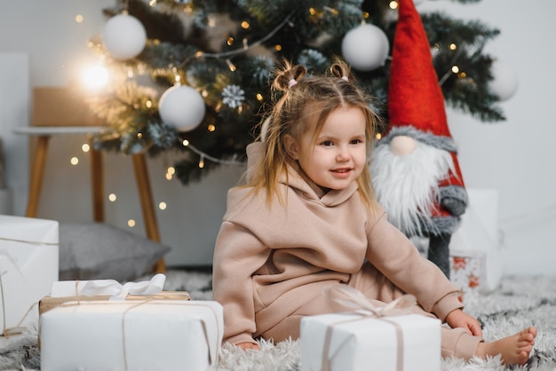 Niña linda cerca del árbol de navidad