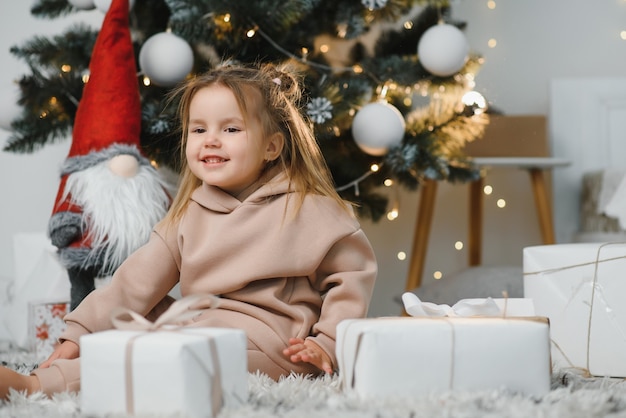 Niña linda cerca del árbol de navidad