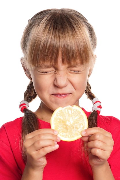 Una niña linda comiendo limón fresco aislada sobre un fondo blanco