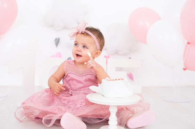 niña linda comiendo pastel de cumpleaños y celebrando su primer cumpleaños