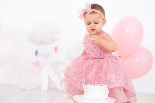 niña linda comiendo pastel de cumpleaños y celebrando su primer cumpleaños
