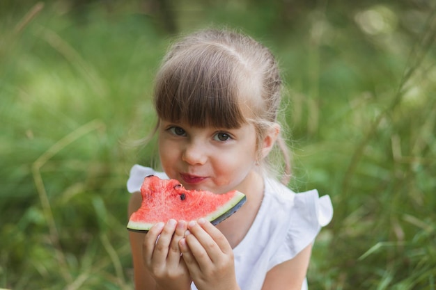 Niña linda comiendo sandía en verano