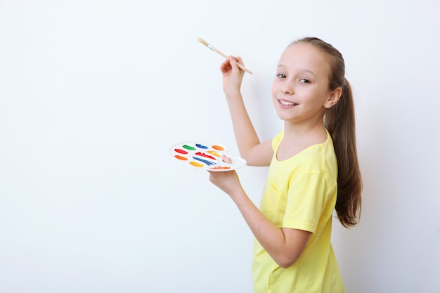 Niña linda dibuja pinturas en casa