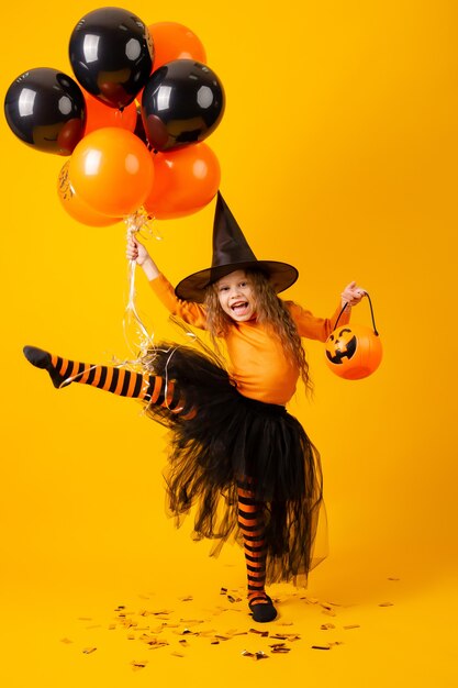 Niña linda en un disfraz de bruja para Halloween