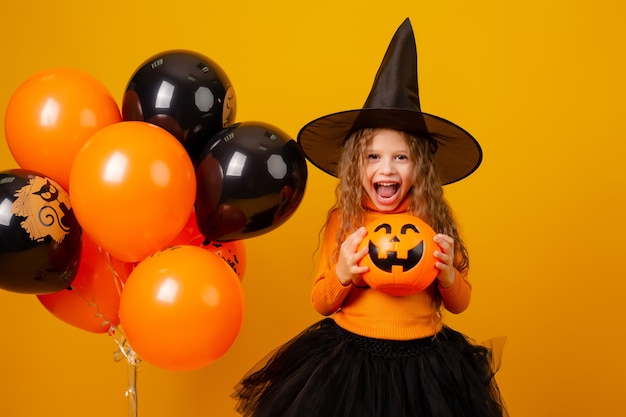 Niña linda en un disfraz de bruja para Halloween