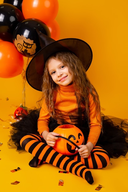 Niña linda en un disfraz de bruja para Halloween