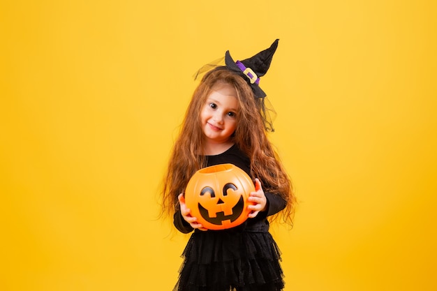 Niña linda en un disfraz de bruja de Halloween