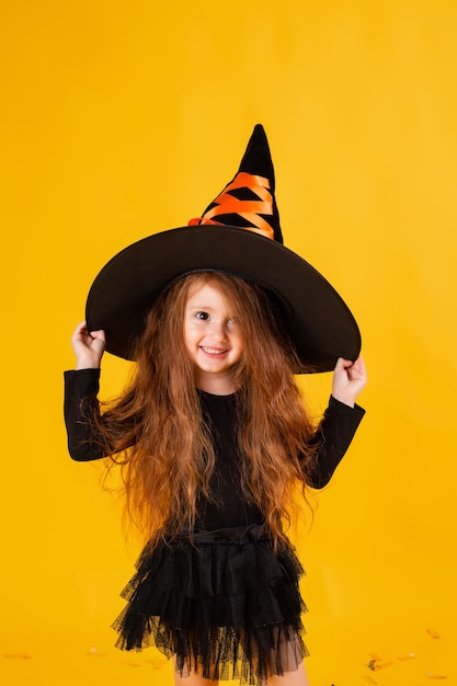 Niña linda en un disfraz de bruja de Halloween