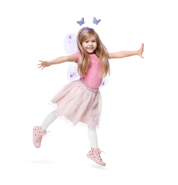 Una niña linda en disfraz de hada con alas violetas saltando sobre un fondo blanco