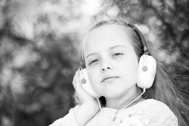 Niña linda disfrutando de la música con auriculares