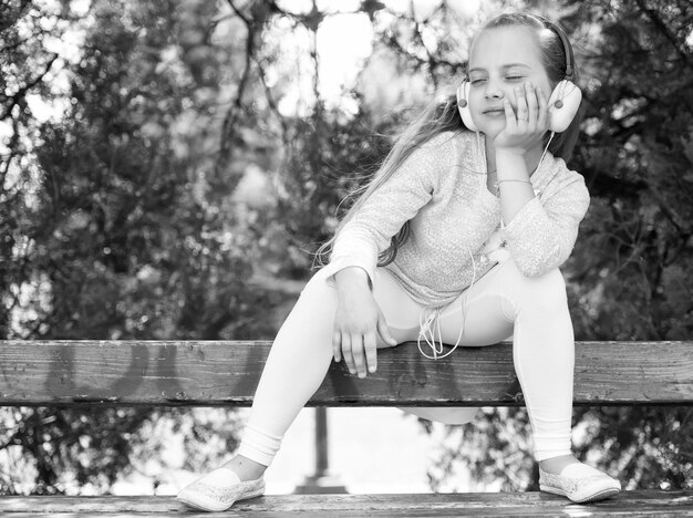 Niña linda disfrutando de la música con auriculares