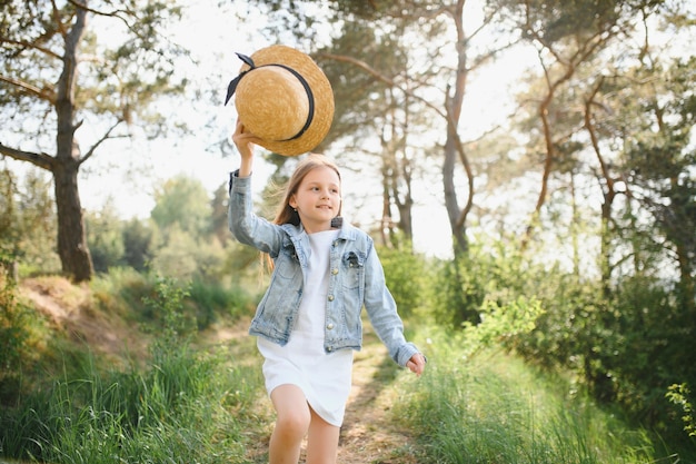 Niña linda divertida en el parque sobre el fondo de la naturaleza Felicidad Temporada de verano