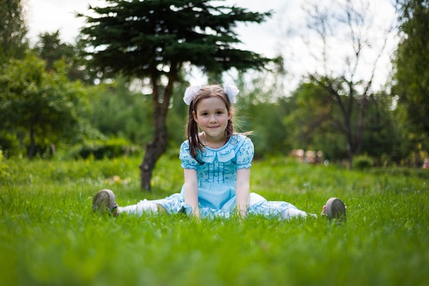 Niña linda divirtiéndose caminando en un parque soleado