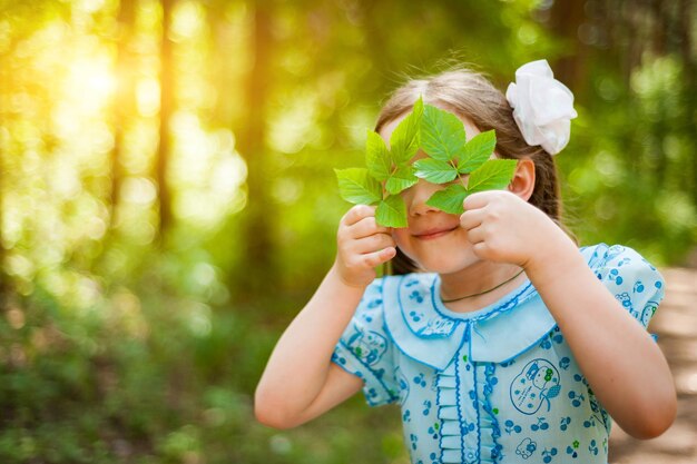 Niña linda divirtiéndose caminando en un parque soleado