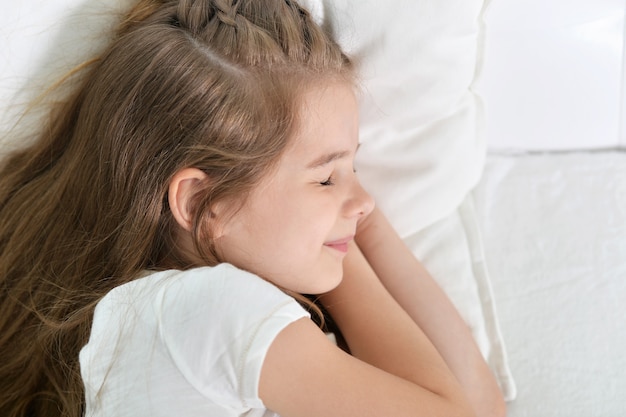 Niña linda durmiendo en una cama