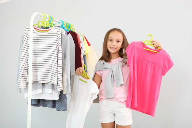 Niña linda elige ropa en el vestidor