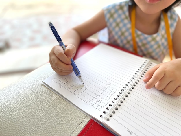 Foto niña linda escribe en su cuaderno