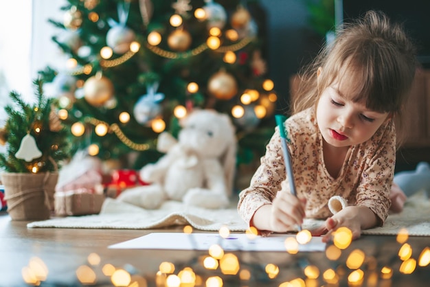 Niña linda escribiendo una carta a Santa Claus