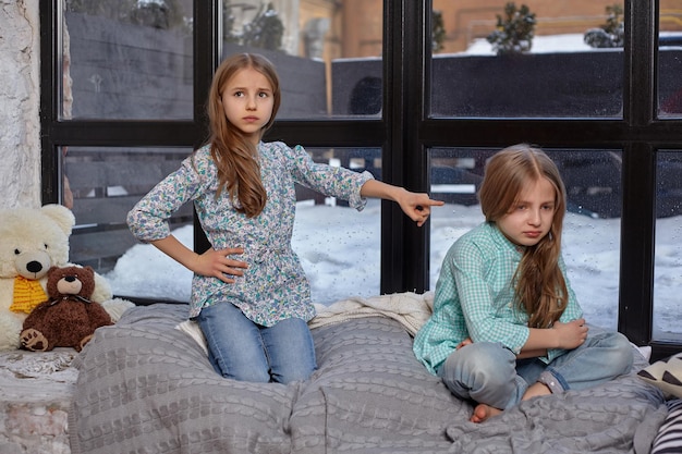 La niña linda está delatando a su hermana señalándola con el dedo