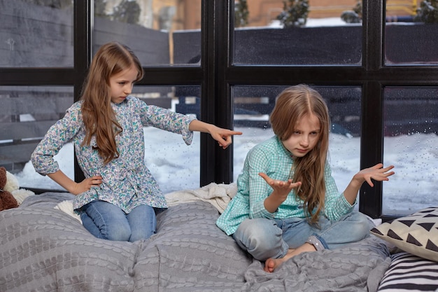 La niña linda está delatando a su hermana señalándola con el dedo