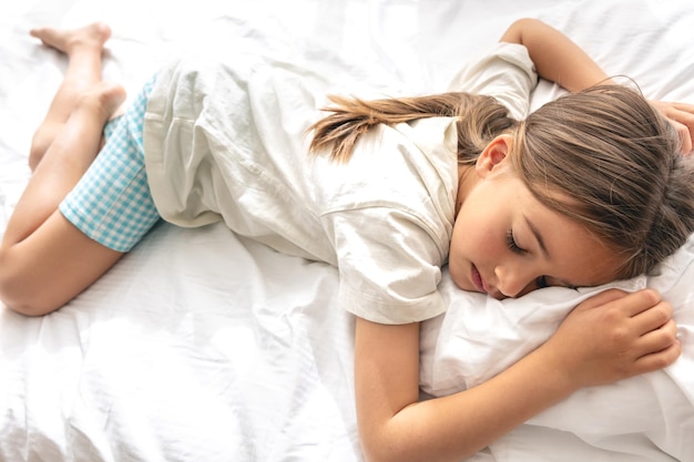 La niña linda está durmiendo en la cama