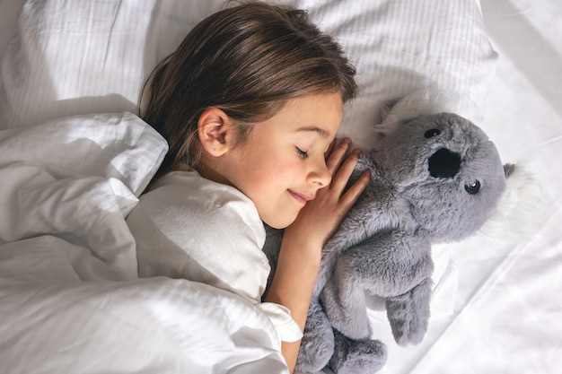 La niña linda está durmiendo en la cama