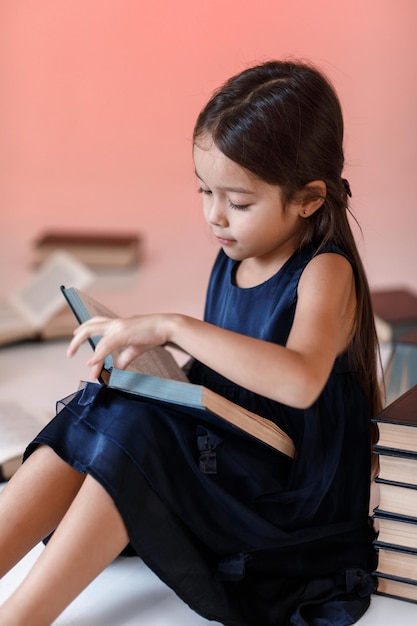 Niña linda está leyendo un libro