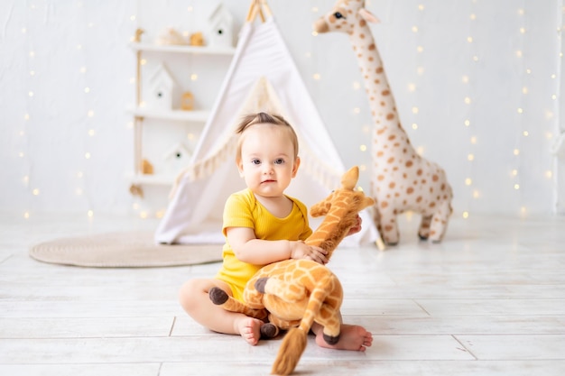 Una niña linda está sentada en una luminosa y acogedora sala de juegos para niños Textiles para niños