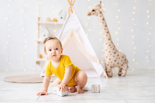 Una niña linda está sentada en una luminosa y acogedora sala de juegos para niños Textiles para niños