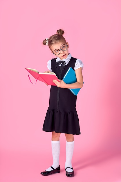 Niña linda con gafas y libros