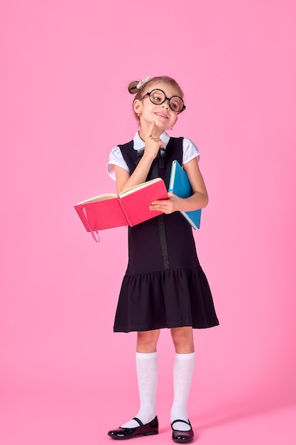 Niña linda con gafas y libros