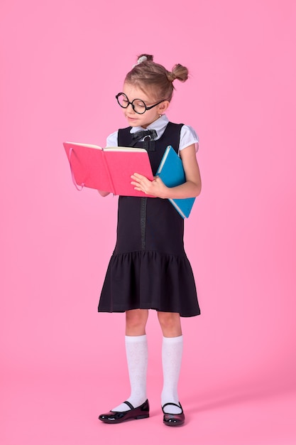 Niña linda con gafas y libros