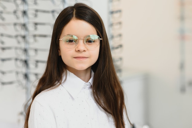 Niña linda con gafas nuevas en la tienda