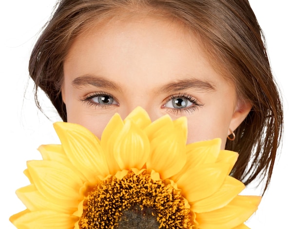 Niña linda con girasol sobre fondo blanco.