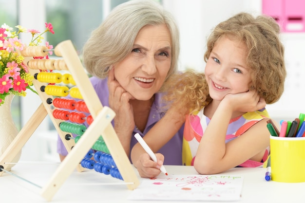 Niña linda haciendo los deberes con la abuela