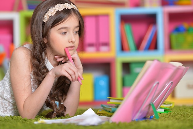 Niña linda haciendo la tarea en la mesa en casa