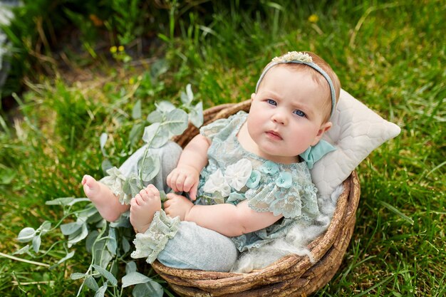 Niña linda en un hermoso arbusto floreciente en el parque en verano