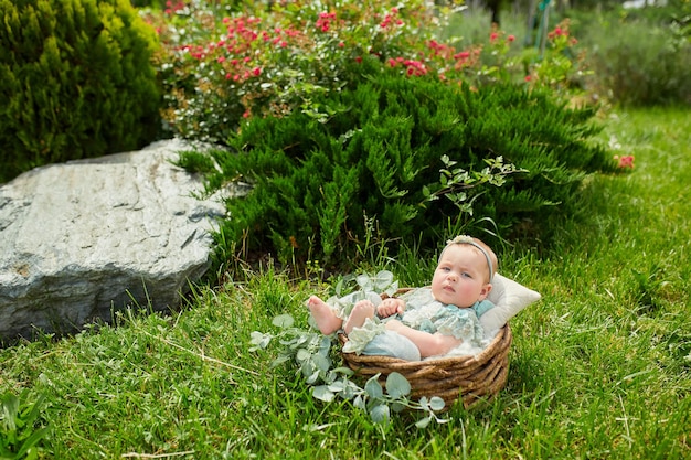 Niña linda en un hermoso arbusto floreciente en el parque en verano