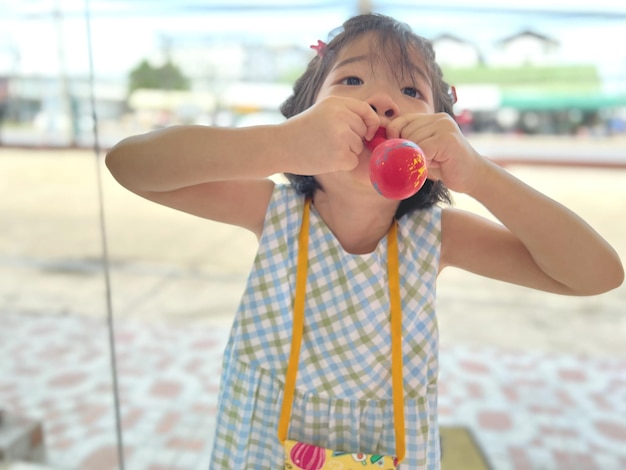 Foto niña linda intenta inflar un globo