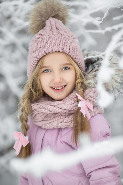 Niña linda en el invierno en la calle antes del año nuevo en la nieve